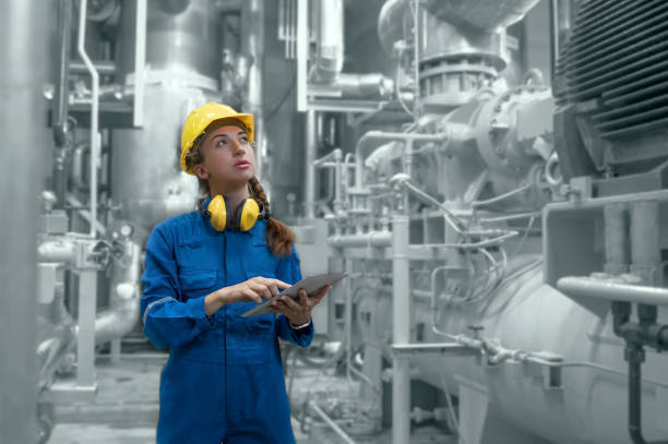 A portrait of an industrial worker using a tablet to inspect work.