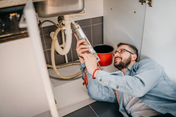 istock Young repairman with tools in his hands is fixing the sink in the kitchen 1324151821