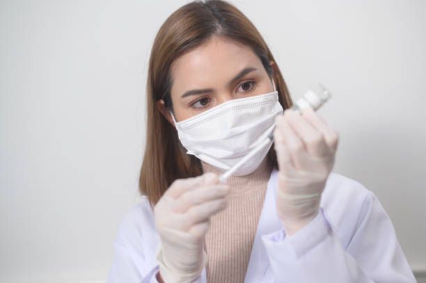 jeune femme médecin tenant une seringue avec flacon de vaccin contre la covid-19 pour injection, vaccination contre la covid-19 et concept de soins de santé - kit mains libres photos et images de collection