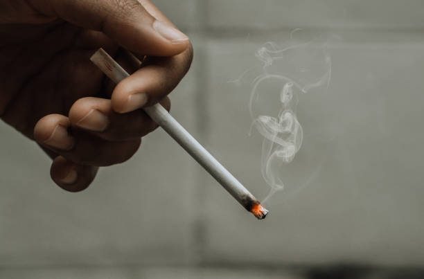 istock woman holding smoking a cigarette in hand. 1324154275