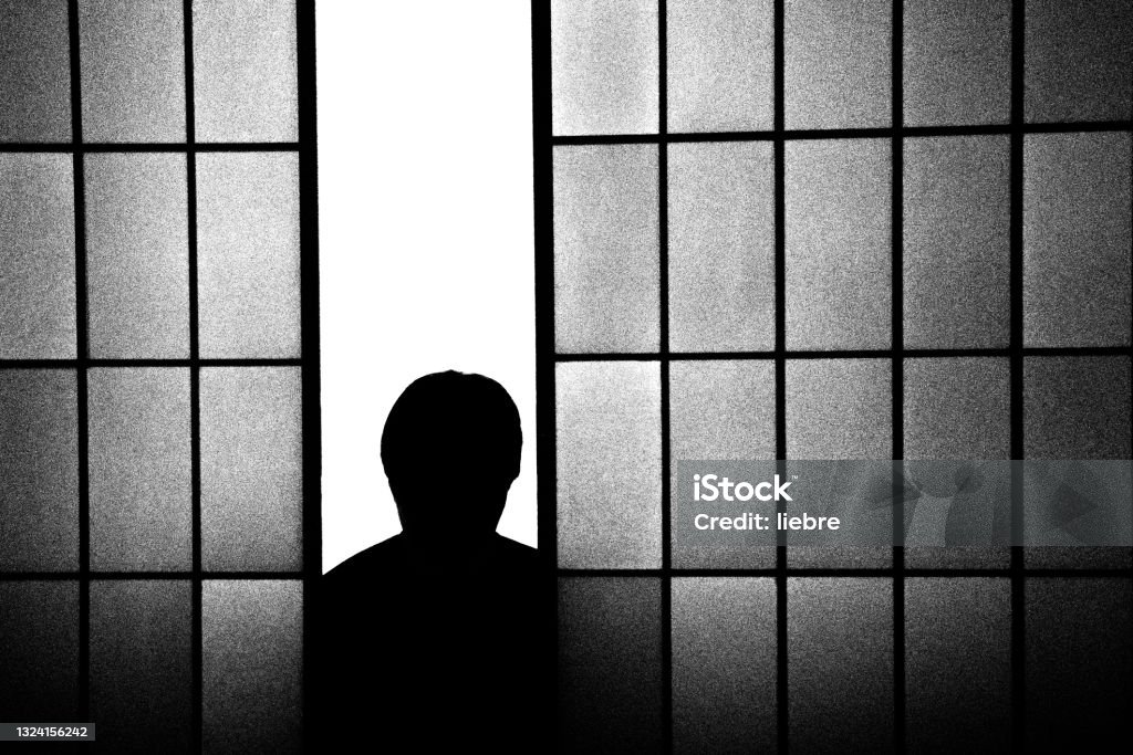 A man' silhouette peeking from a shoji A man' silhouette peeking from a shoji. Horror Movie Stock Photo