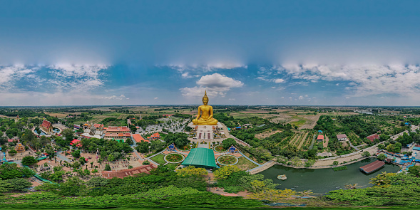 360 degrees panorama aerial view of big ancient golden mediated Buddha at Wat Muang Temple, Ang Thong province, Thailand, drone high angle top view