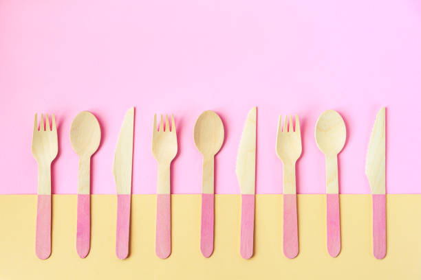 istock Disposable bamboo spoons, forks and knives on yellow and pink background. Zero waste concept. Top view, copy space 1324159028