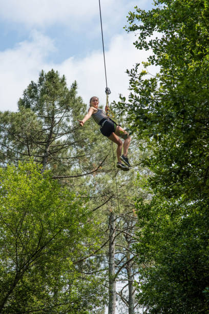 istock pretty young woman in an extreme tree climbing course 1324159029
