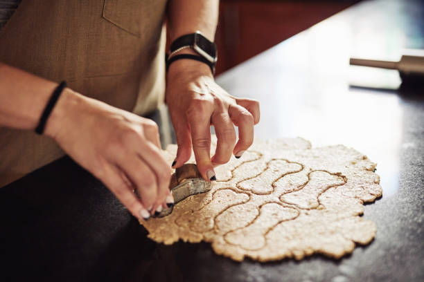 istock Cropped shot of an unrecognizable woman standing alone in her kitchen and using cookie cutters to make dog biscuits 1324162957