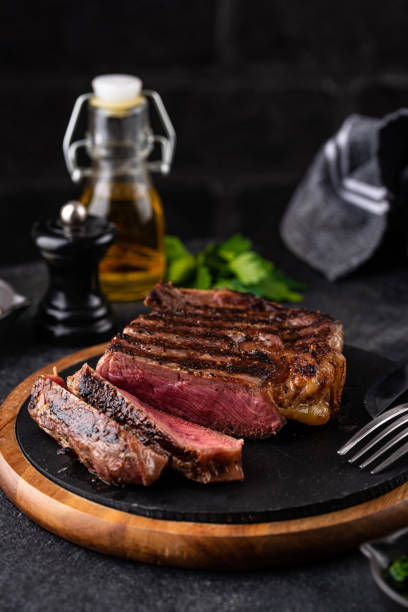 Grilled marbled rib eye steak Grilled marbled rib eye steak with green chimichurri sauce. Roasted barbecued beef meat rib eye steak stock pictures, royalty-free photos & images