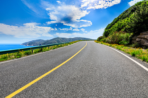 Asphalt highway and mountain with blue sea natural landscape.