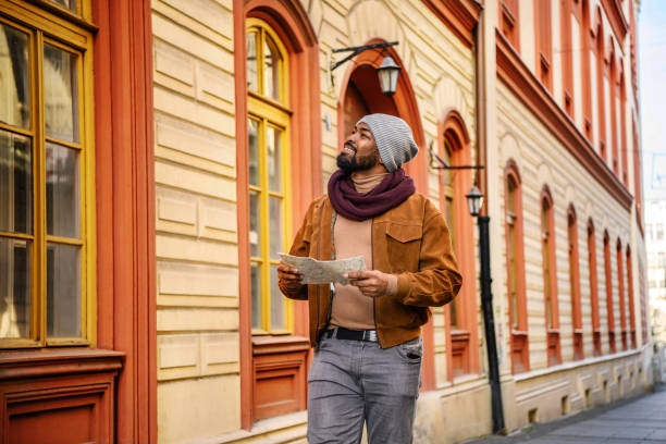 Tourist of African Ethnicity is Enjoying in Exploration the City During the Vacation Using a City Map and Looking for Sights to See.
