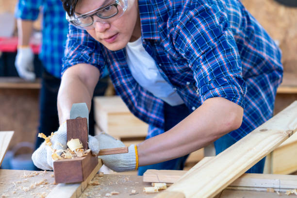 istock A carpenter is using a wood sharpener. Carpenter using back planer shavings manually on wooden board. 1324169029