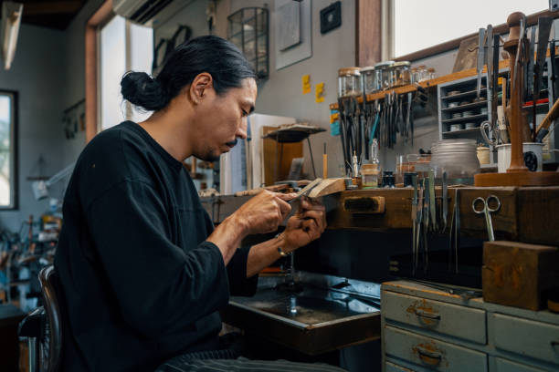 istock Mid adult silversmith polishing a silver ring by hand 1324170556