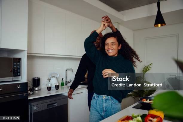Mixed race couple having fun in the kitchen. Mixed race couple dancing together. High quality photo