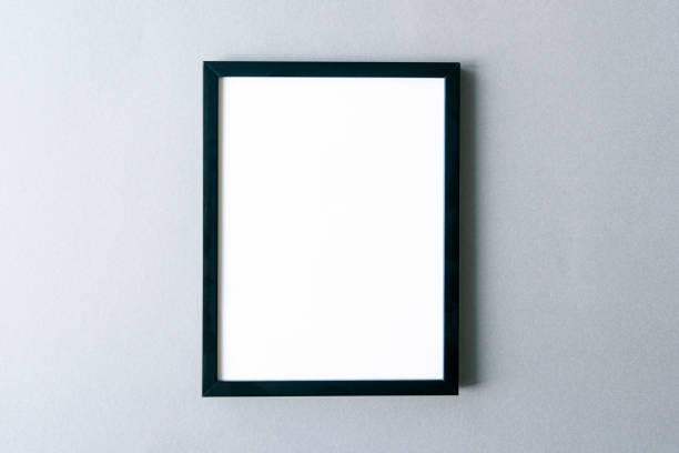 istock Frame mockup, black photo frame with blank surface on gray wall. Space for text. 1324171733