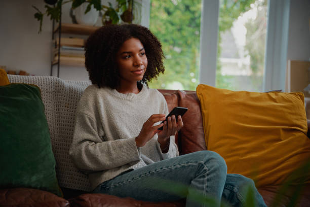 istock Woman thinking while holding smartphone in hand before typing message 1324177385