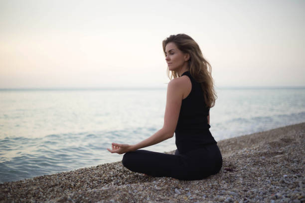 istock young beautiful woman meditates while sitting by the sea 1324178239