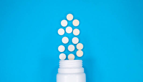 istock Pharmaceutical medicine pills or tablets and bottle on blue background. Copy space for text. 1324180963