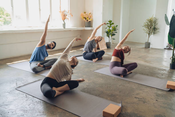 asian yoga students observing and practicing during class - yoga posture women flexibility imagens e fotografias de stock