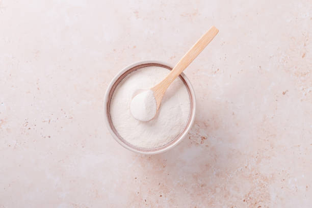 istock Collagen powder and spoon on beige stone background, top view 1324185014