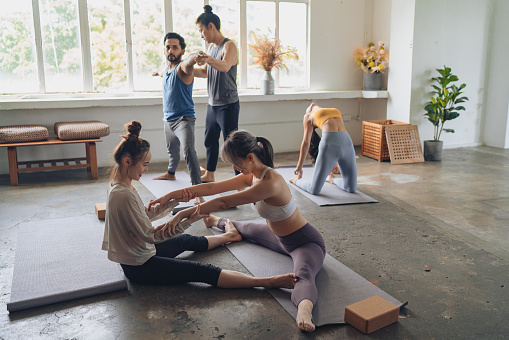 Yoga students in various forms of stretching exercises during class