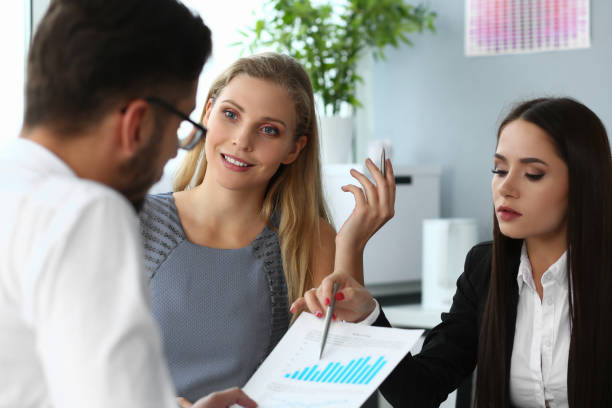 istock Group of smiling people discussing financial papers 1324186836