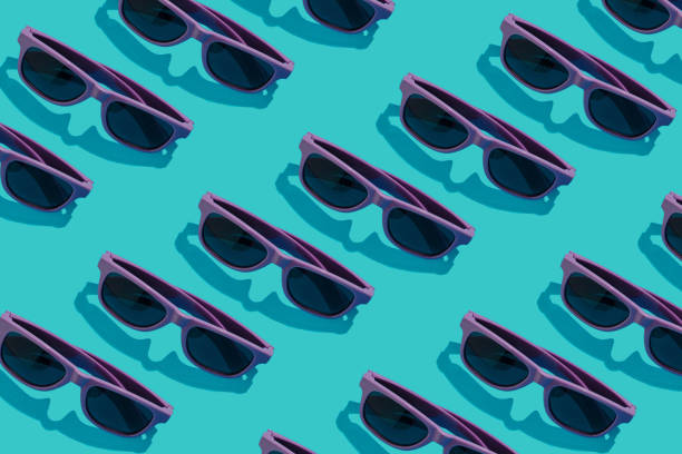 istock Purple sunglasses lay down on a pastel blue background. Flat lay pattern composition, summer chill out concept 1324187925