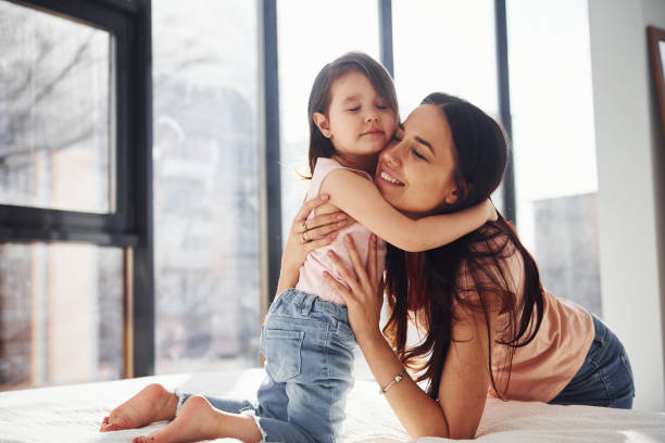 istock Young mother with her daughter embracing each other on bed 1324191033
