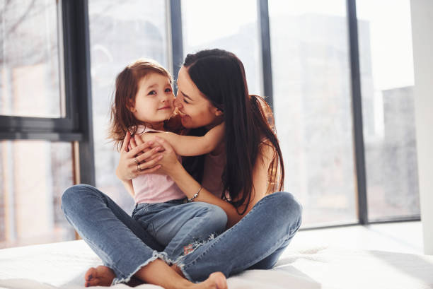 istock Young mother with her daughter embracing each other on bed 1324191052