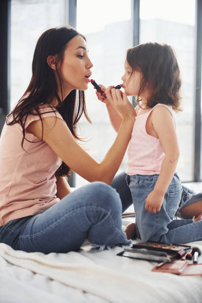 istock Learning how to make up. Young mother with her daughter spending weekend together in room 1324191294