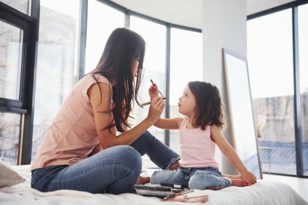 istock Learning how to make up. Young mother with her daughter spending weekend together in room 1324191325