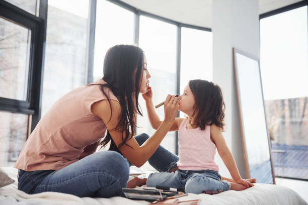 istock Learning how to make up. Young mother with her daughter spending weekend together in room 1324191983