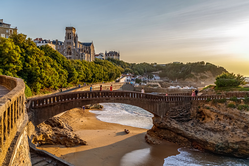 Biarritz, Francia. Vista del famoso puente de piedra Rocher du Basta, paisaje urbano y costa con playas de arena y puerto para pequeñas embarcaciones. Hora de oro. Vacaciones en Francia. photo