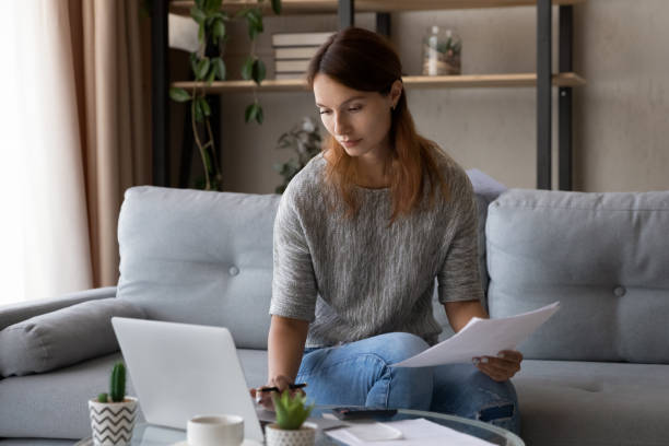 istock Confident woman calculating expenses, using laptop, checking financial documents 1324194512
