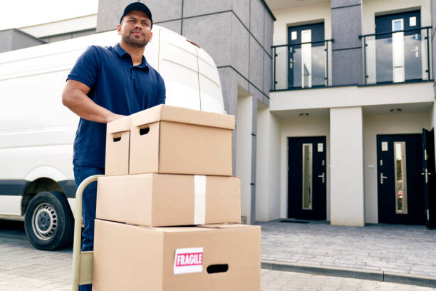 Courier carrying packages on a hand truck stock photo