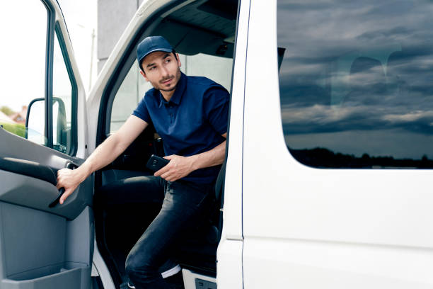 istock Courier with mobile phone gets out of the car 1324195249