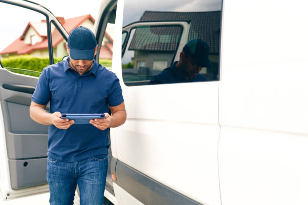 Driver with digital tablet gets out of the car