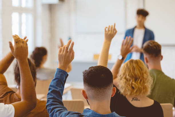 istock Young man and woman asking questions in classroom 1324196595