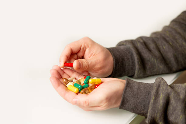 istock Man holding pile of pills 1324196651