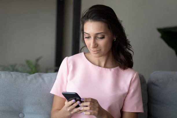 istock Close up Arabian woman using smartphone, sitting on couch 1324196736