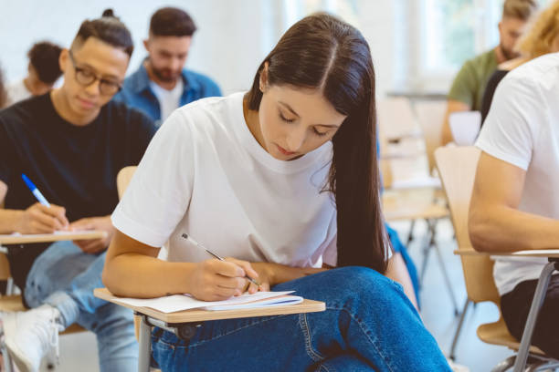 istock Young woman with long hair writing during exam 1324197779