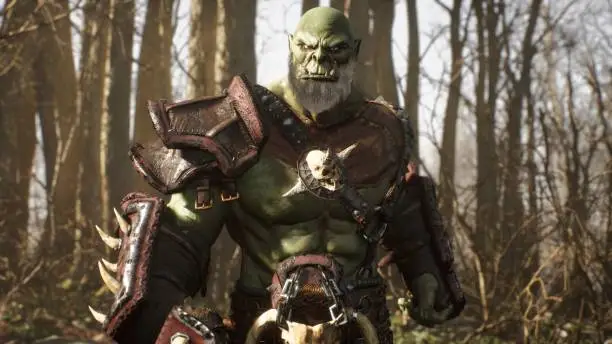 A formidable orc warrior trains before battle and demonstrates combat skills. Fantasy medieval concept. View of the fighting orc warrior in the fabulous green forest.