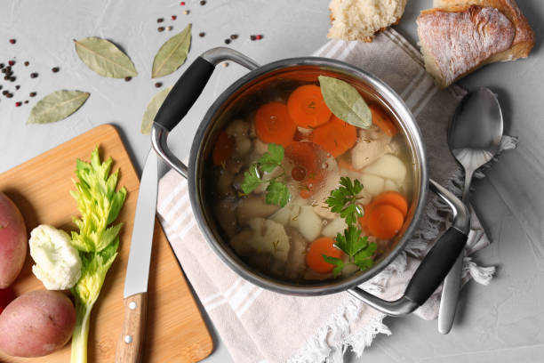 istock Pot of delicious vegetable bouillon and ingredients on light grey table, flat lay 1324205857