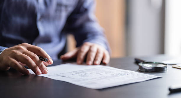 hombre que rellena el formulario de impuestos - pen contract writing signature fotografías e imágenes de stock