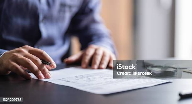 Man Filling In The Tax Form Stock Photo - Download Image Now - Contract, Law, Legal System