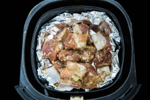 Photo of Raw Fresh pork ribs mix with garlic and pepper on a foil
