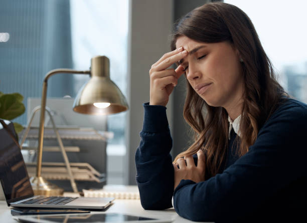 istock Shot of a young businesswoman experiencing a headache while at work 1324210466