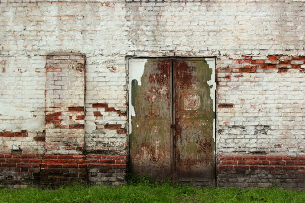 istock Old metal doors. Flaking paint and rust on gates of abandoned building. 1324211707
