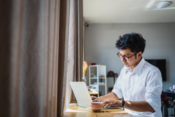istock Young Asian business man working with laptop computer while sitting at home 1324212048