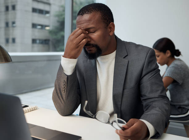 istock Shot of a young businessman experiencing a headache at work 1324213299