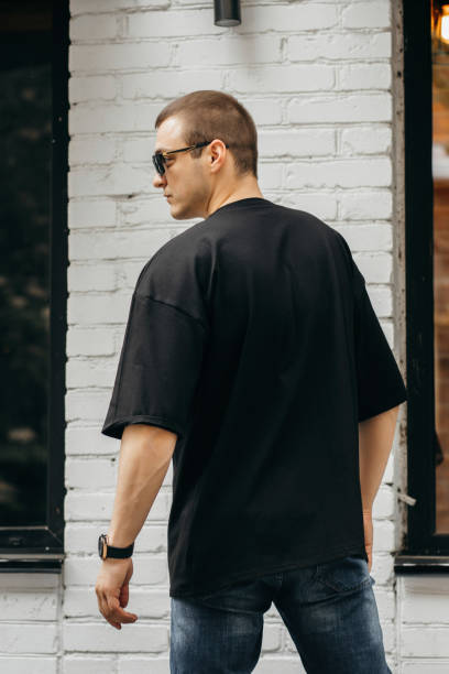 homem vestindo camiseta em branco preto com espaço para o seu logotipo ou design. zombe - back rear view men muscular build - fotografias e filmes do acervo