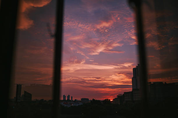 istock Sunset looking through window at city with reflection on window with sunset 1324220253