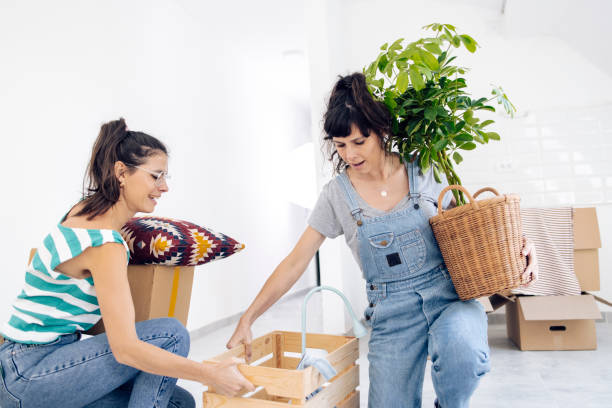 istock Young woman helping her twin sister while moving in 1324223313